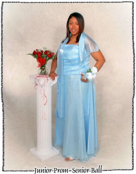 Sharee as a junior in high school wearing a prom dress and posing for a full length photo with a corsage on her wrist.