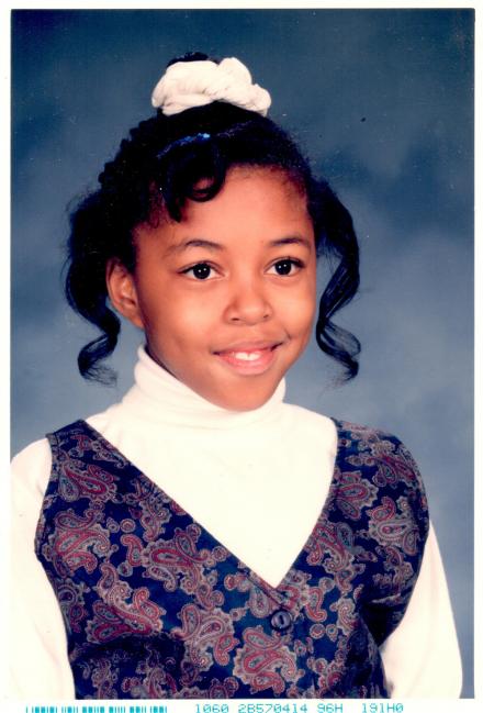Head and shoulder shot of Sharee in fourth grade, with her hair pulled into a pony tail.